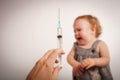 The child is afraid of a syringe, the girl yells and does not want to give an injection. Children`s fear of medical procedures. A Royalty Free Stock Photo