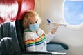 Child in airplane in face mask. Virus outbreak