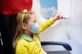 Child in airplane in face mask. Virus outbreak