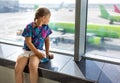 Child at the airport near the window is looking at airplanes Royalty Free Stock Photo