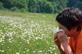 Child with an allergy to pollen while you blow your nose with a Royalty Free Stock Photo