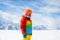 Child in alpine ski school with magic carpet lift and colorful training cones going downhill in the mountains on a sunny winter Royalty Free Stock Photo