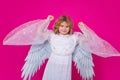 Child angel. Portrait of cute kid with angel wings isolated on pink studio background. Little angel, valentines day