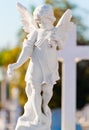 Child angel statue leaning in a cross Royalty Free Stock Photo