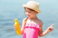 Child applying sunblock cream. girl holding sunscreen lotion in hand. Sun care on beach.