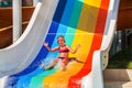 Child at aquapark slides down the water slide. Royalty Free Stock Photo