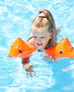 Child with armbands playing in swimming pool. Royalty Free Stock Photo