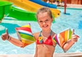 Child with armbands playing in swimming pool