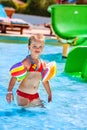 Child with armbands playing in swimming pool