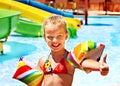 Child with armbands playing in swimming pool.