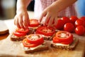 child arranging tomato slices on whole grain bread