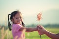 Child asian little girl giving grass flower to her mother Royalty Free Stock Photo