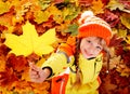 Child in autumn orange leaves.