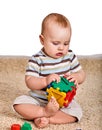 Child baby boy plying with puzzle toy on floor. Royalty Free Stock Photo