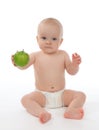 Child baby girl toddler sitting in diaper and eating green apple Royalty Free Stock Photo