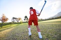 Child, ball and hockey on green grass for game, sports or outdoor practice match in nature. Rear view of young kid or