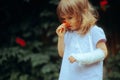 Girl with a Broken Arm in Orthopedic Plaster Smelling Flower