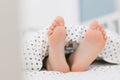 Child bare feet bed under blanket Royalty Free Stock Photo