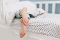 Child bare feet bed under blanket Royalty Free Stock Photo