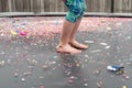 Child with bare feet bouncing on trampoline covered in confetti Royalty Free Stock Photo