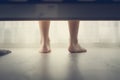 Child bare feet photo from under the bed.