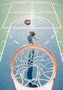 Child in basketball uniform jumping with basket ball for shot on basketball court.