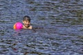 The child is bathing in the lake with the ball Little boy is swimming in the lake in the summer. Royalty Free Stock Photo