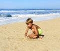 The child in a bathing suit playing on the sand