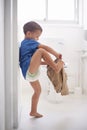 Child, bathroom and toilet training for learning growth, milestone or hygiene. Male person, kid diaper and pants or step Royalty Free Stock Photo