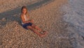 Child on Beach, Kid Playing at Sunset, Girl Throwing Pebbles in Sea Water