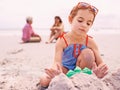 Child, beach and sandcastle building on holiday for summer travel with family for environment, playing or swimwear. Girl Royalty Free Stock Photo