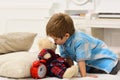 Child in bedroom kiss toy in nose. Good night concept. Boy with happy face puts favourite toy on bed, wishing sweet