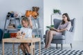 A child with behavioral problems hitting a teddy bear during a therapeutic meeting with a therapist in a