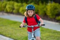 Child on bicycle. Boy in a helmet riding bike. Little cute caucasian boy in safety helmet riding bike in city park Royalty Free Stock Photo