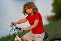 Child on bicycle. Boy in a helmet riding bike. Little cute caucasian boy in safety helmet riding bike in city park Royalty Free Stock Photo