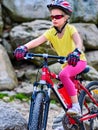 Child on bicycle ride mountain. Girl traveling in summer park. Royalty Free Stock Photo