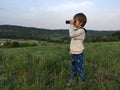Child with binocular, on the hillside