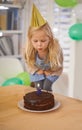 Child, birthday and blow cake candle in home, celebration for three year old or party wish. Happy girl, dessert on table Royalty Free Stock Photo