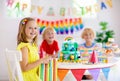 Child birthday party. Kids blow candle on cake Royalty Free Stock Photo