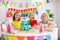 Child birthday party. Kids blow candle on cake Royalty Free Stock Photo