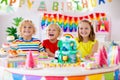 Child birthday party. Kids blow candle on cake Royalty Free Stock Photo