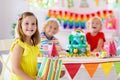 Child birthday party. Kids blow candle on cake Royalty Free Stock Photo