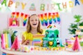 Child birthday party. Kids blow candle on cake Royalty Free Stock Photo