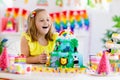 Child birthday party. Kids blow candle on cake Royalty Free Stock Photo