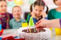 Child on birthday party prepared blowing candles on cake, selecti