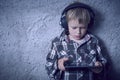 Child blond Boy listening to music or watching movie with headphones and using digital table Royalty Free Stock Photo