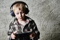 Child blond Boy listening to music or watching movie with headphones and using digital table Royalty Free Stock Photo