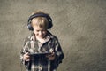 Child blond Boy listening to music or watching movie with headphones and using digital table Royalty Free Stock Photo