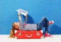 Child blonde girl with pink vintage suitcase and city map ready for summer vacation. Travel and adventure concept Royalty Free Stock Photo