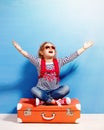 Child blonde girl with pink vintage suitcase ready for summer va